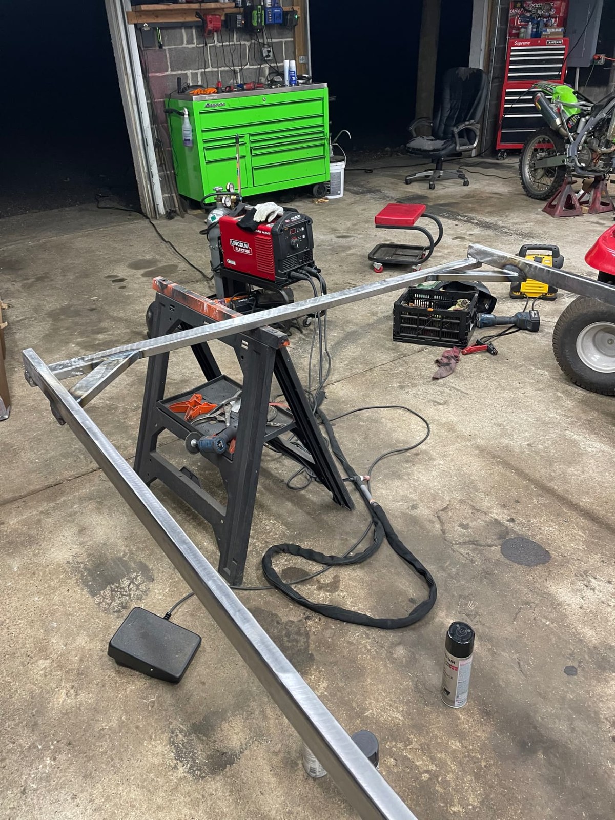 Newly welded aluminum square tube frame resting on sawhorses in the Garage 23 shop