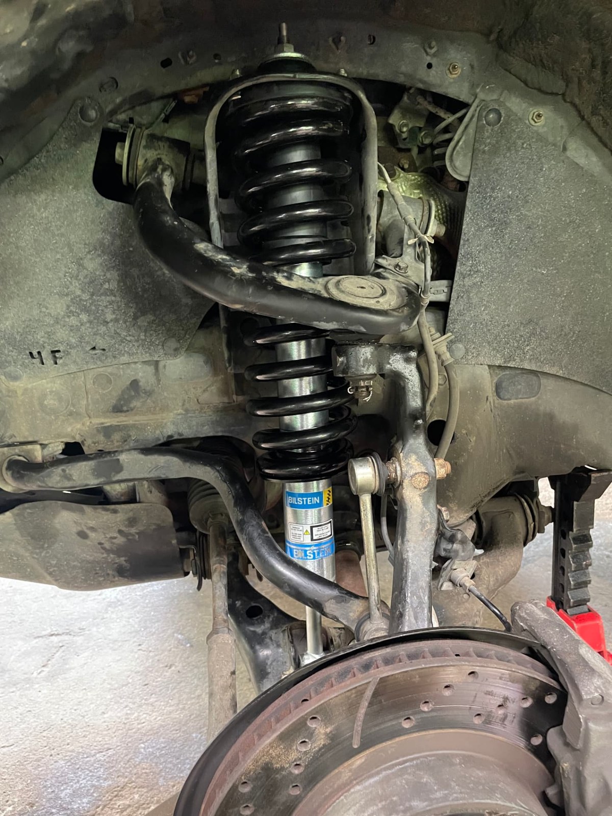 New Bilstein strut and coil spring assembly installed on a vehicle's front suspension