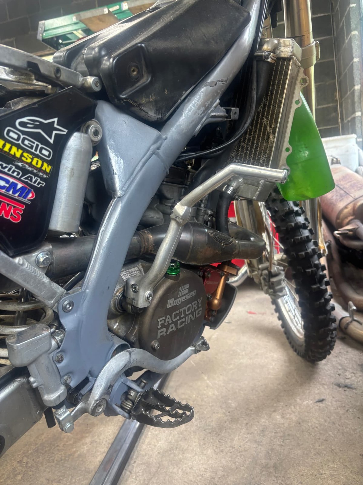 Custom welded and painted frame on a two-stroke motocross bike during a rebuild