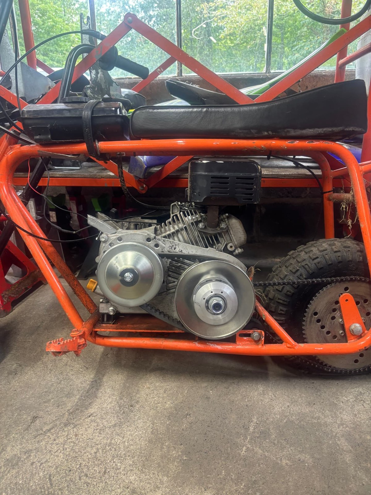 Go-kart engine with a new torque converter and belt drive installed on an orange frame