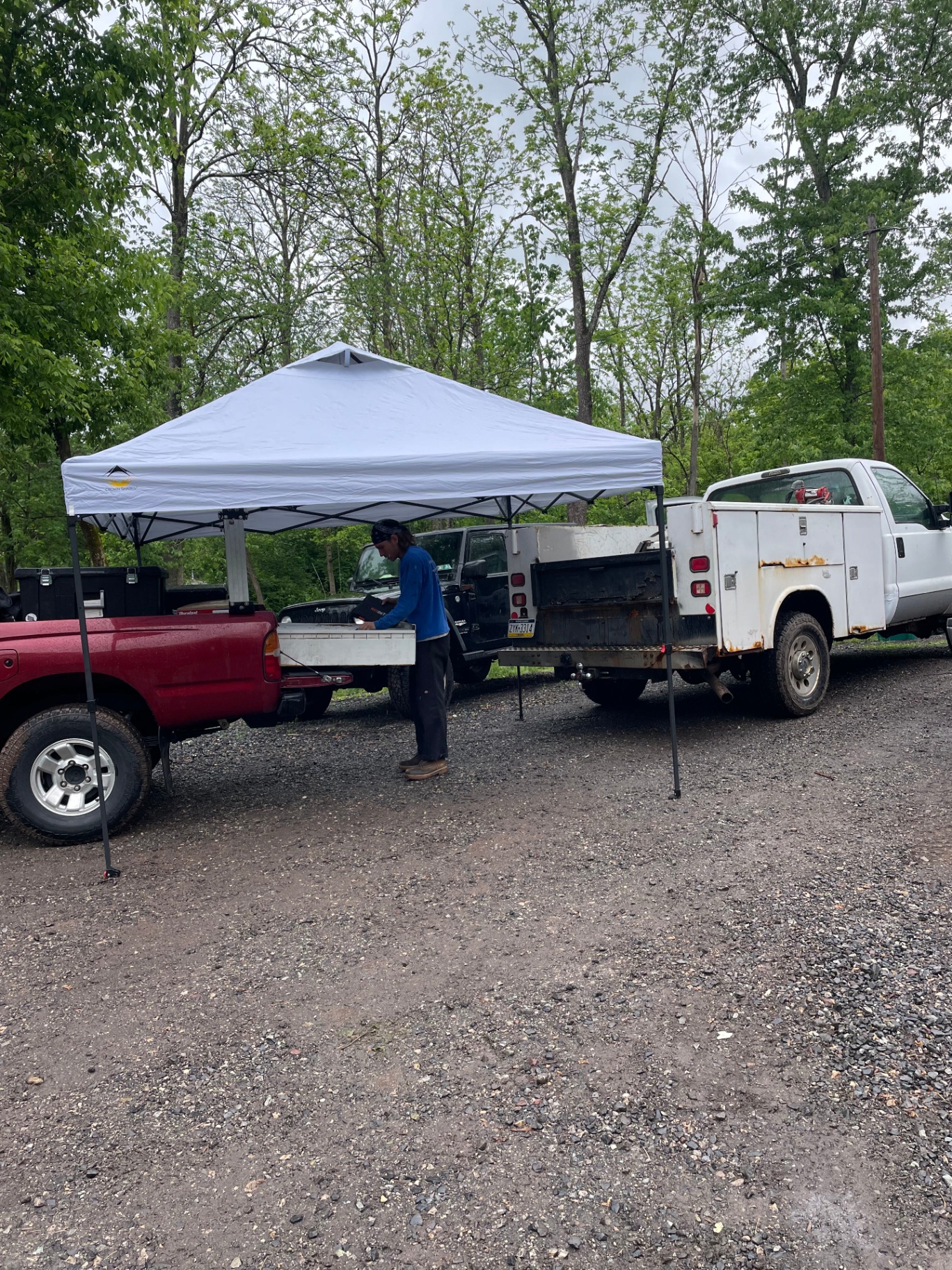G23 mobile mechanic working out of a pop-up canopy service setup between two work trucks