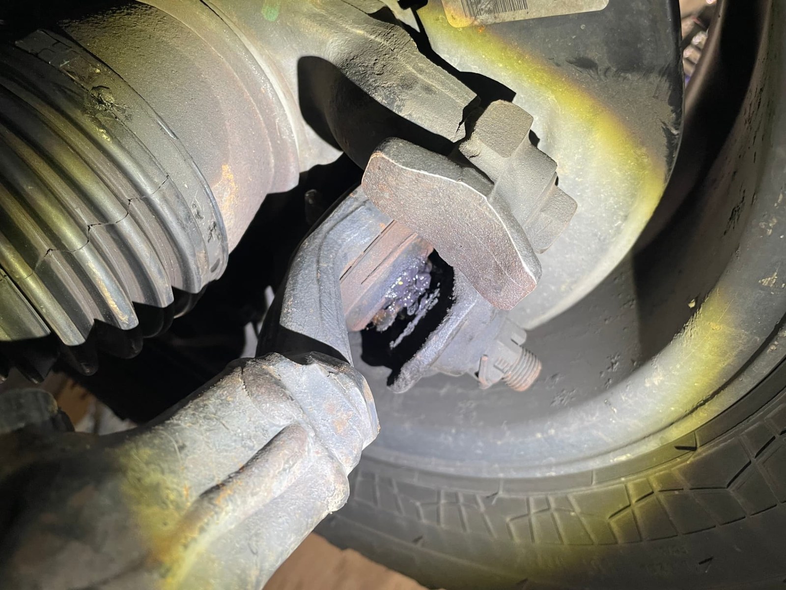 Cracked CV axle boot and seized brake caliper pin discovered during a brake inspection
