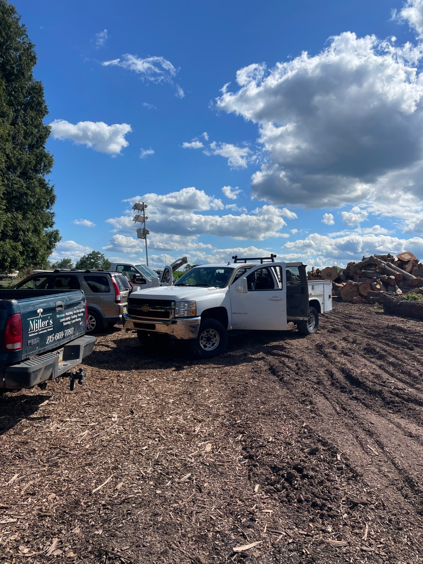 G23 Solutions service truck parked on-site next to a Chevy Silverado 2500HD undergoing repair
