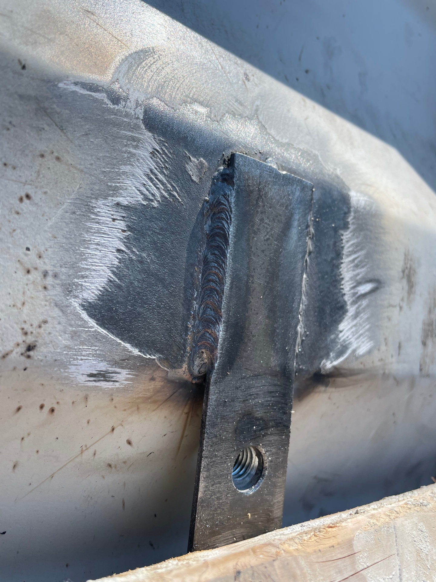 Custom fabricated steel bracket welded to a trailer frame for equipment mounting