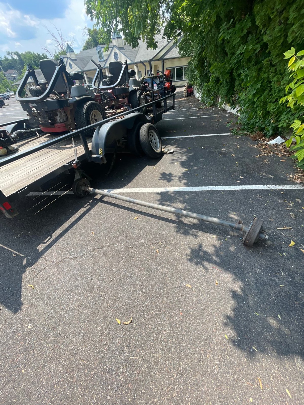Trailer axle removed and laid on the ground during an axle replacement service