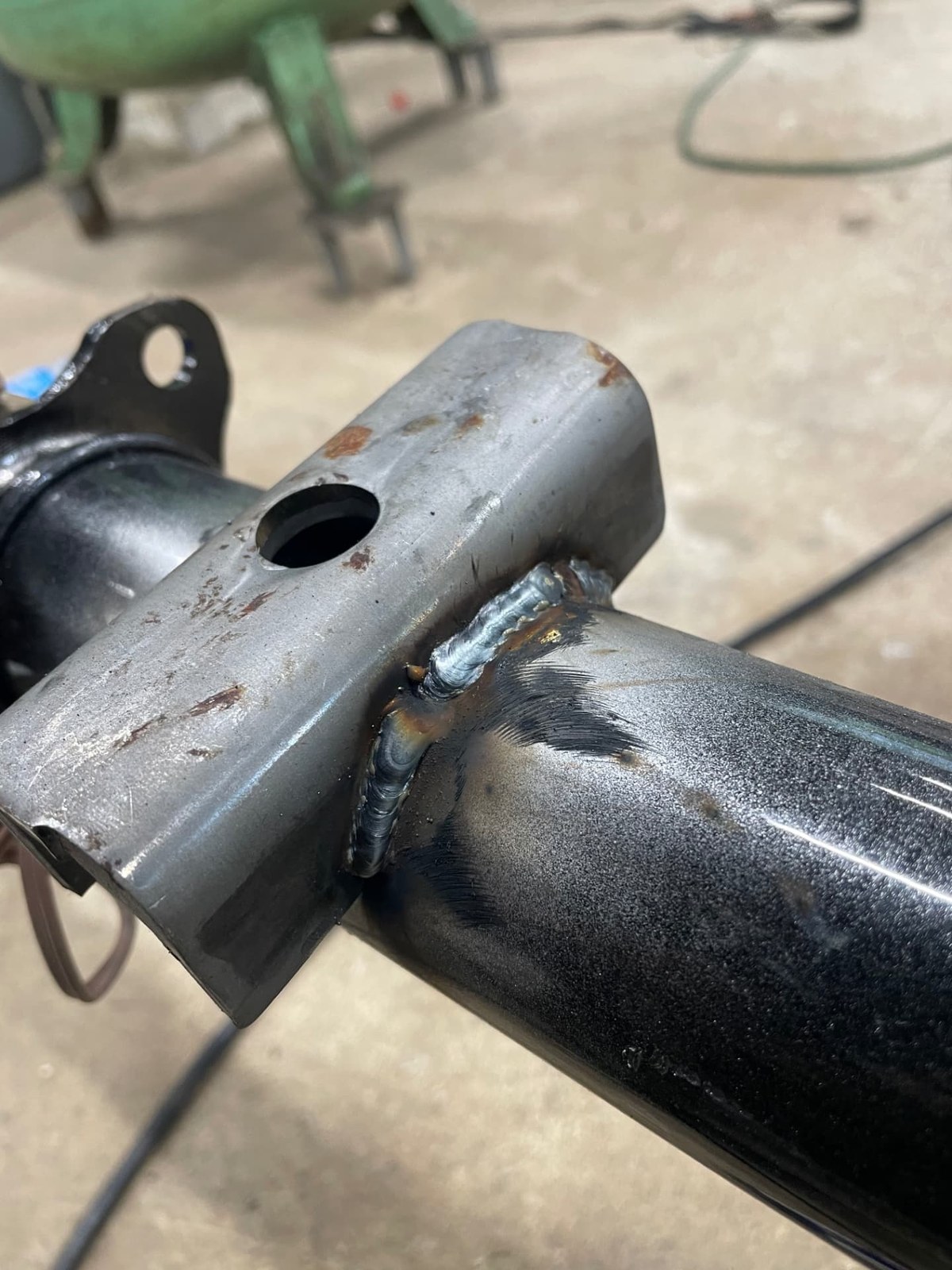 Freshly welded bracket on a trailer axle beam during repair