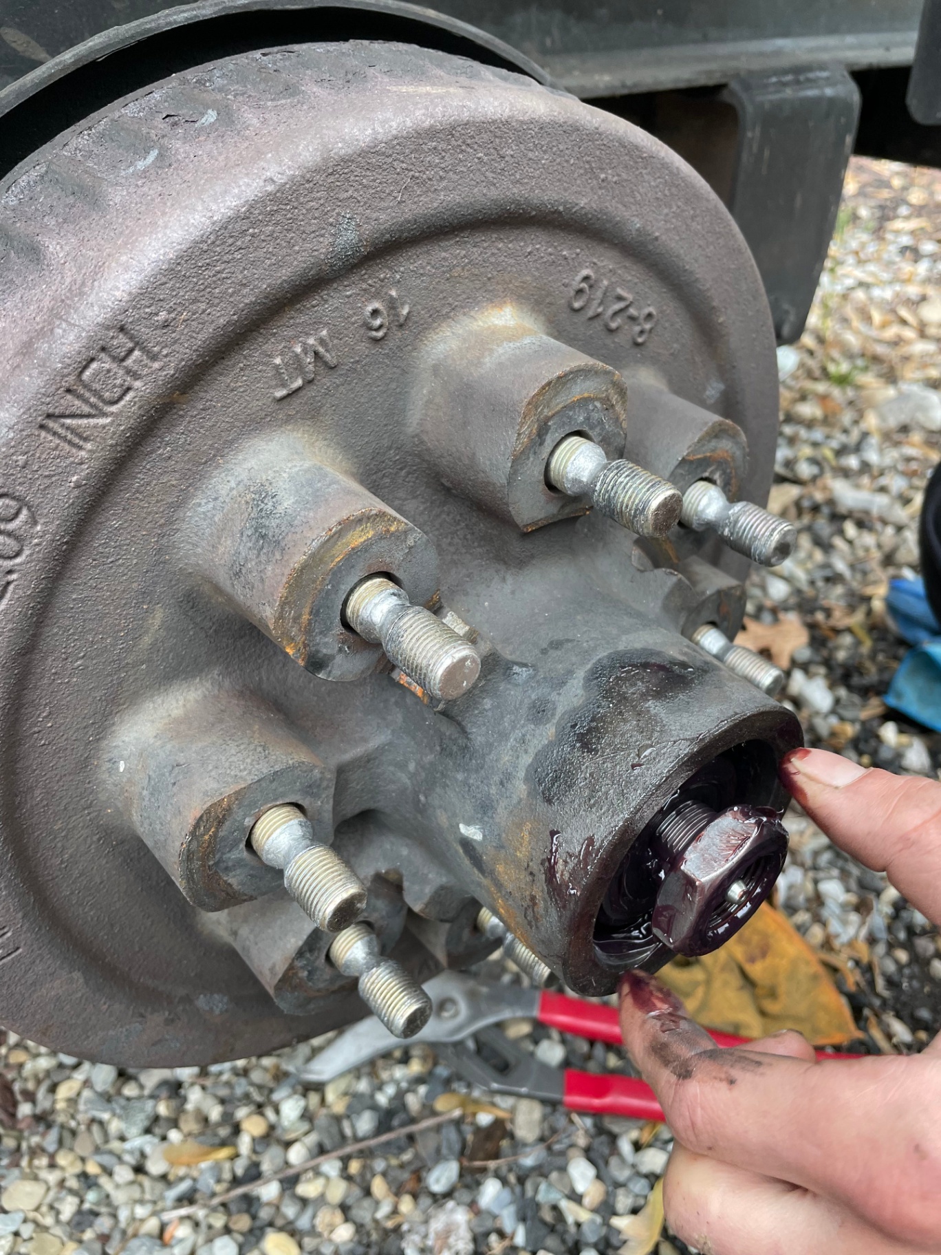 Trailer wheel hub with studs exposed during a bearing repack and brake service