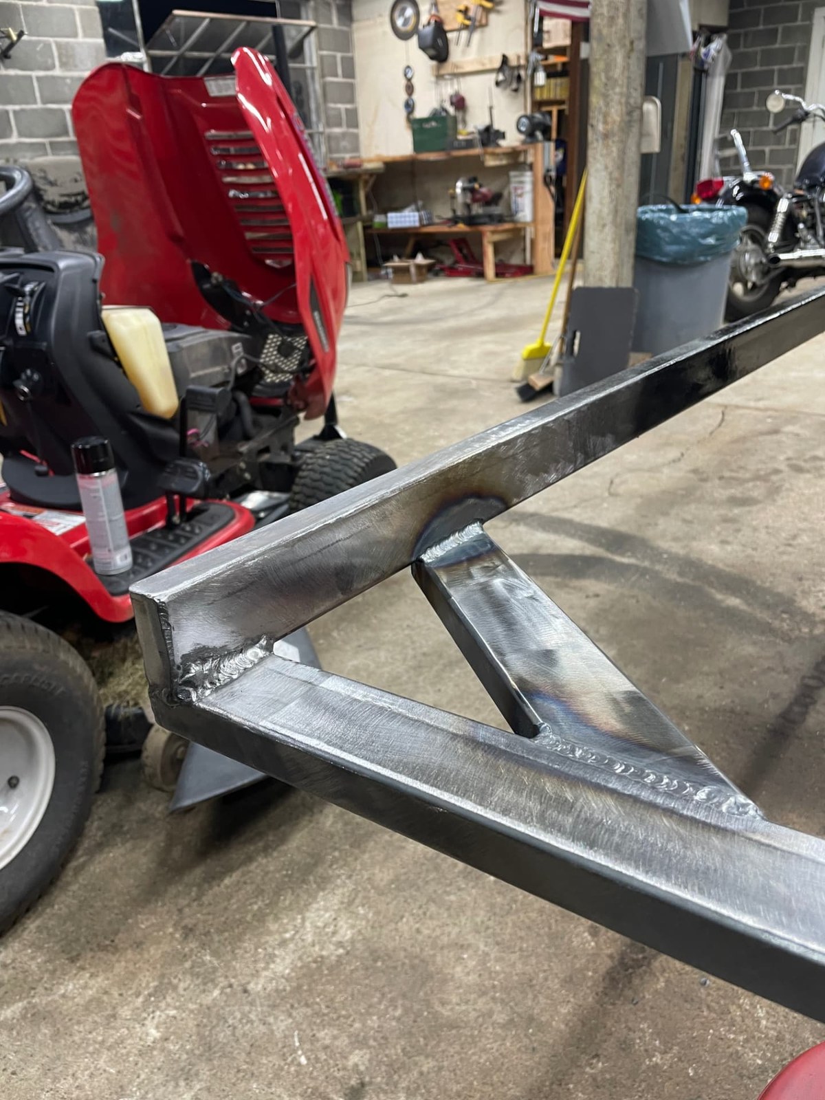Close-up of a welded steel bracket joint with clean finished welds on a tube frame